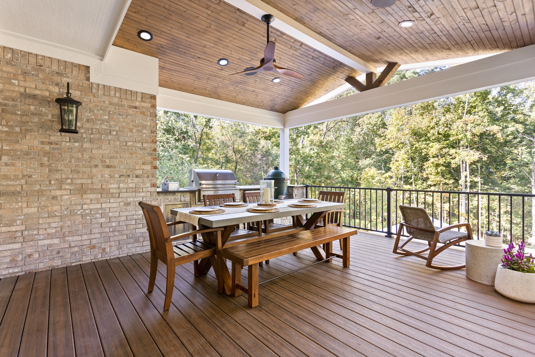 BPI outdoor living space with wooden patio, grill, and dinner table