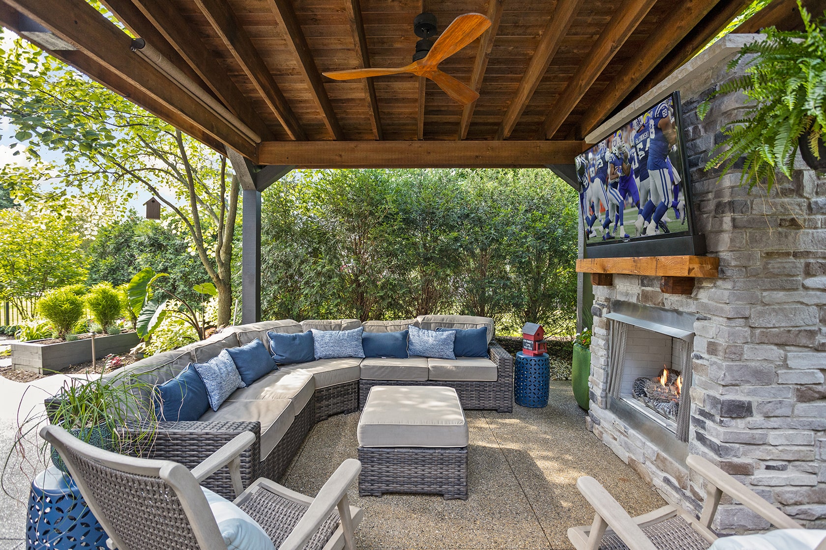 covered outdoor living area with fire feature and outdoor tv