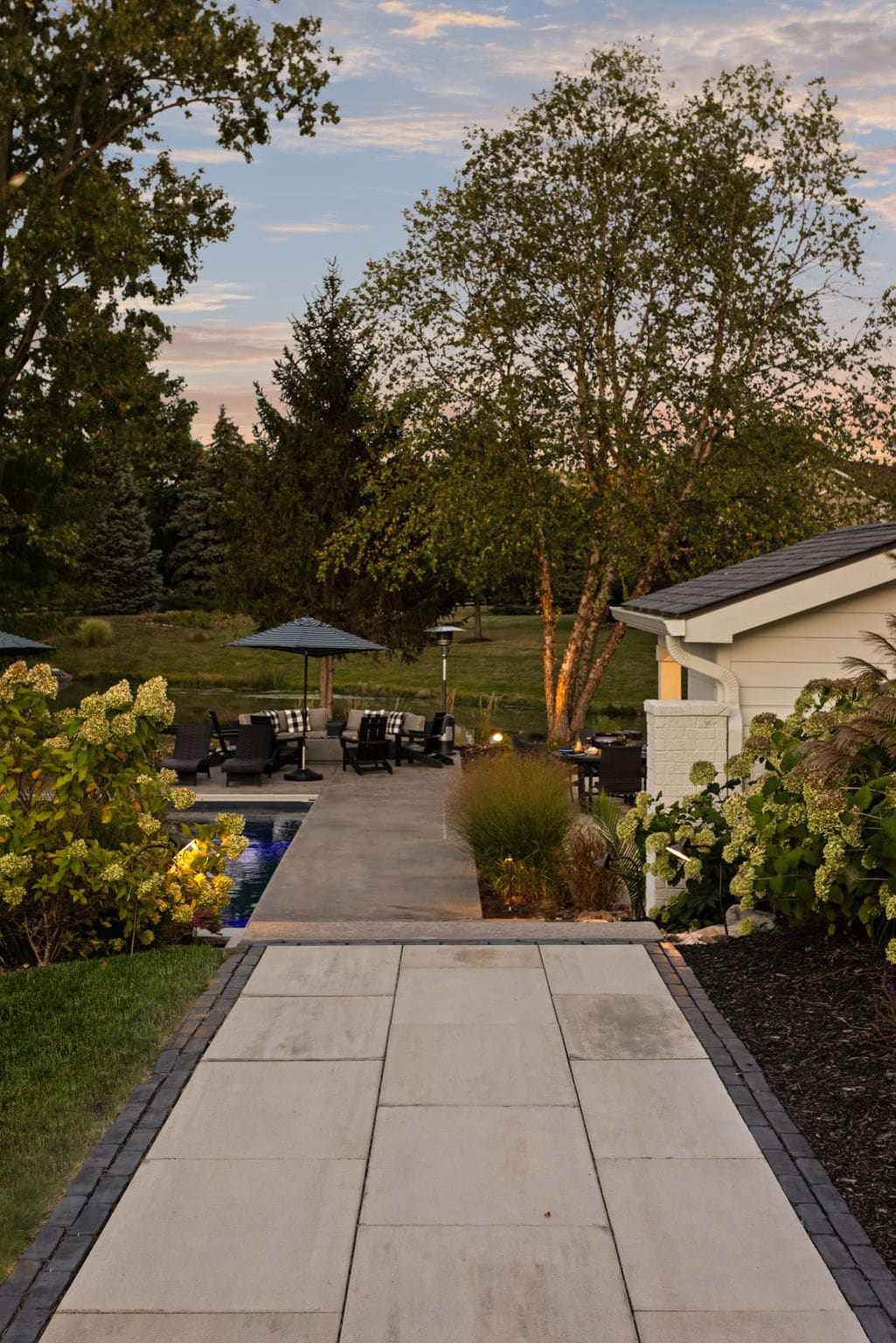 Paver pathway through an elegant backyard garden.