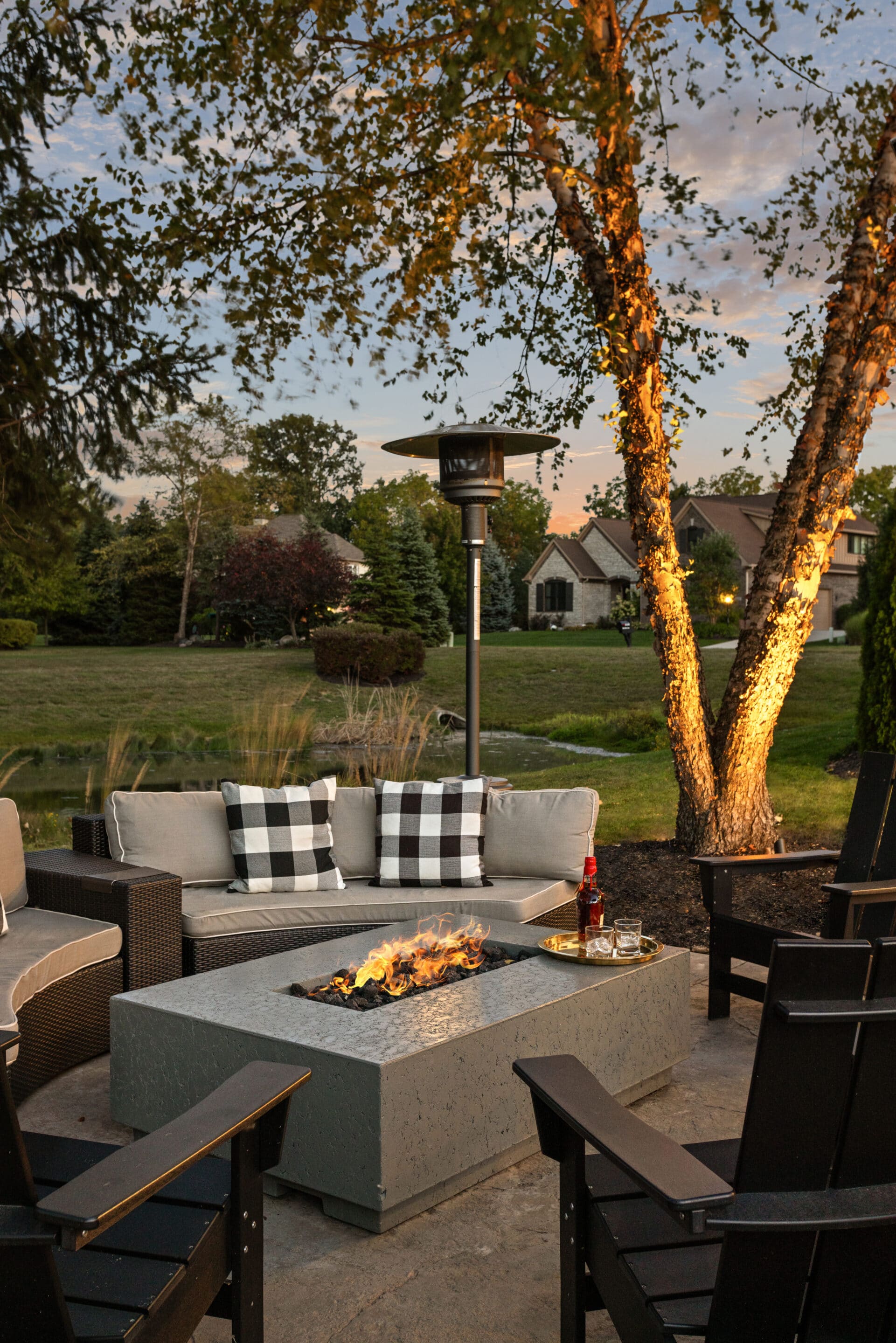 Outdoor fire feature surrounded by seating in a backyard.