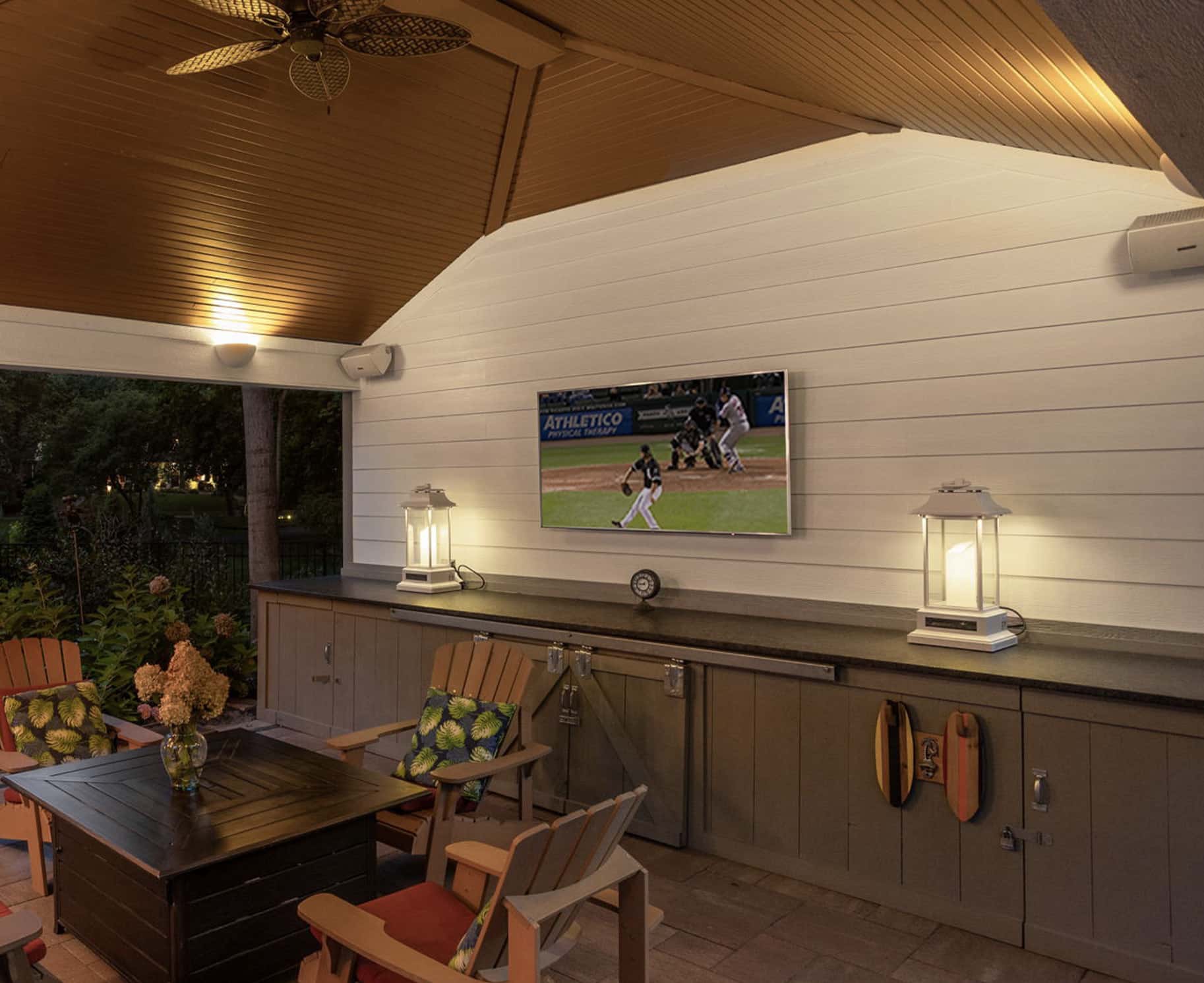 outdoor covered space with tv, audio and seating area around fire pit