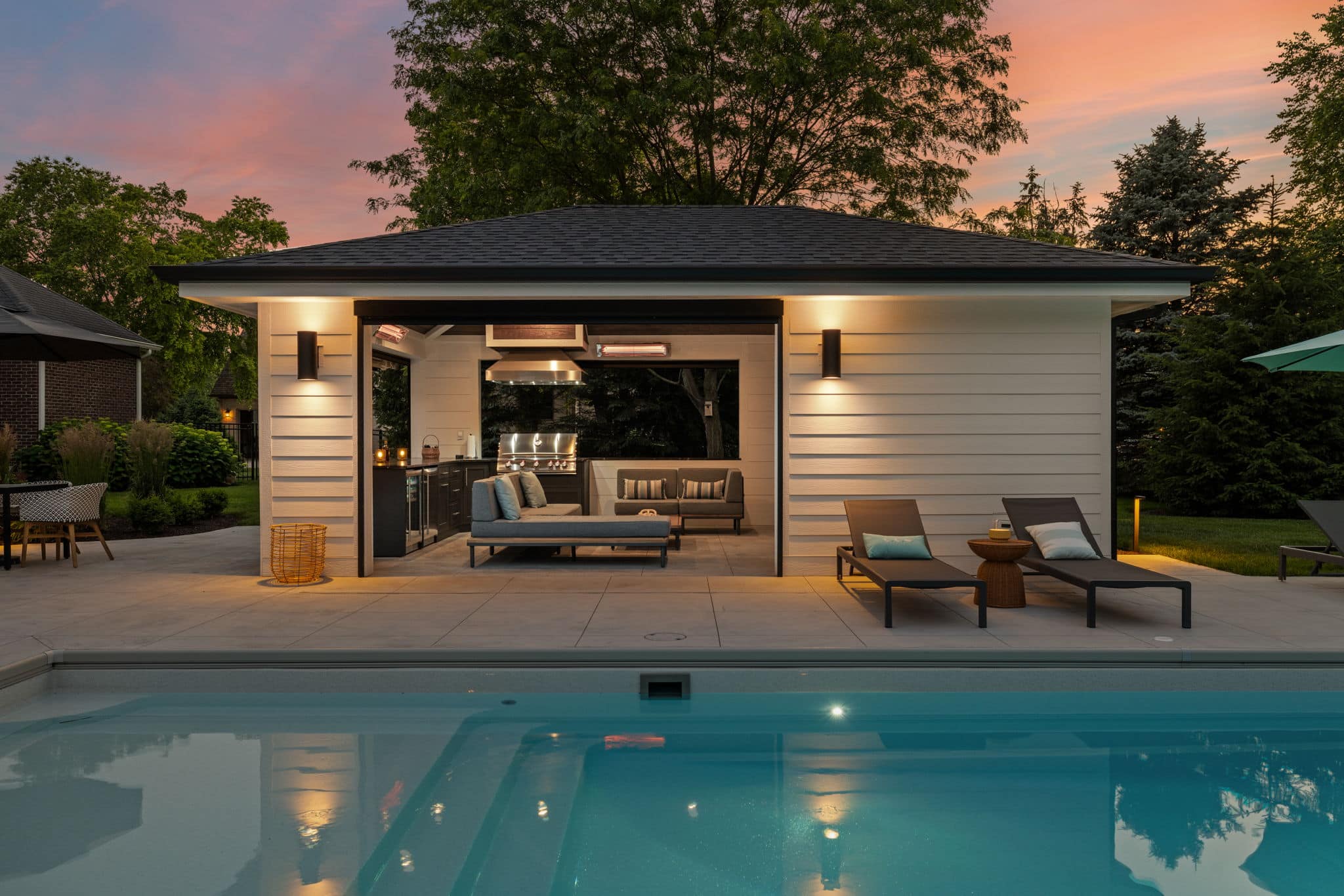 Luxury entertainment space with a beautiful pool and pool house with kitchen and lounge area