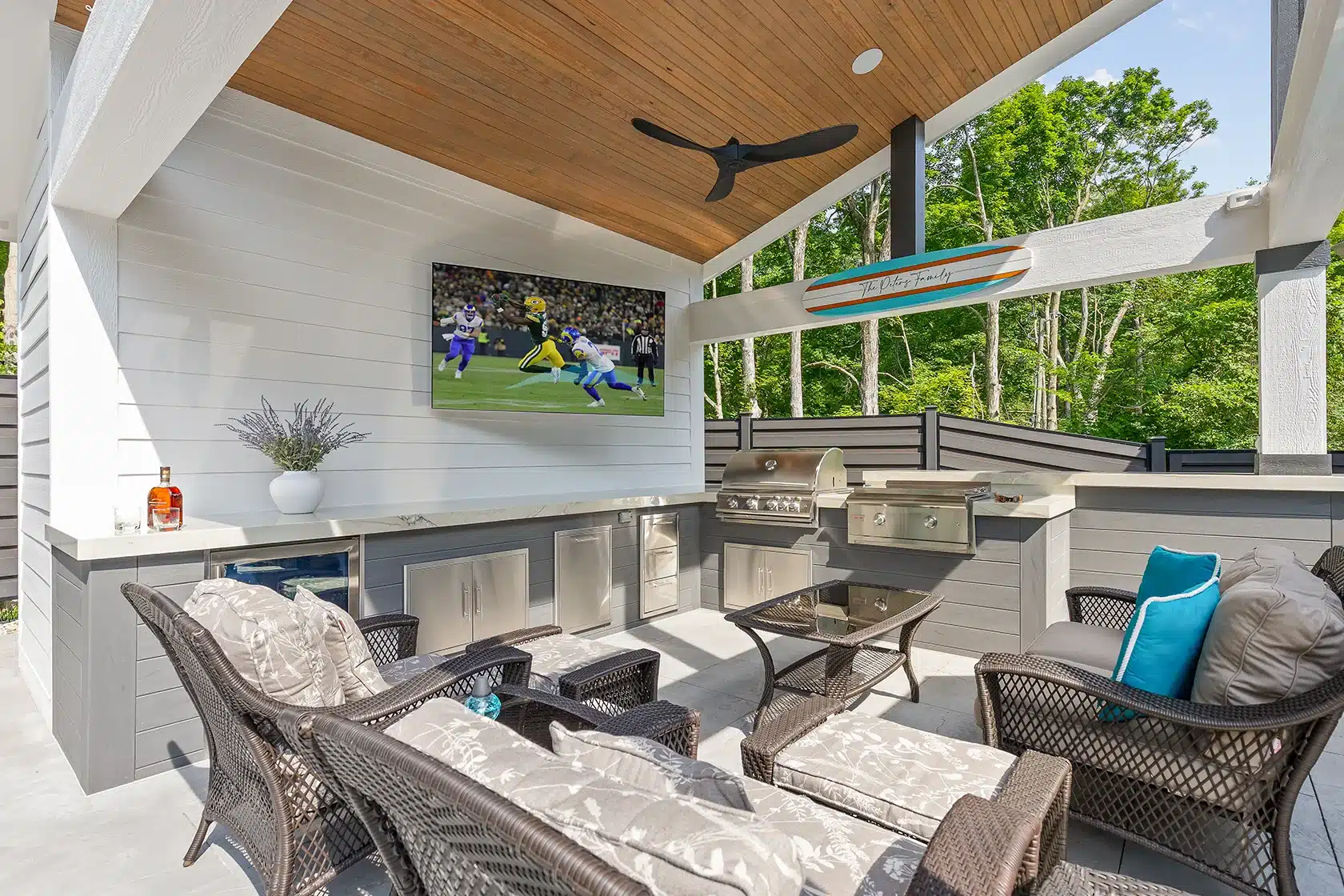 Covered outdoor space Covered poolside pavilion with outdoor kitchen, lounge seating, television and wood-paneled ceiling.