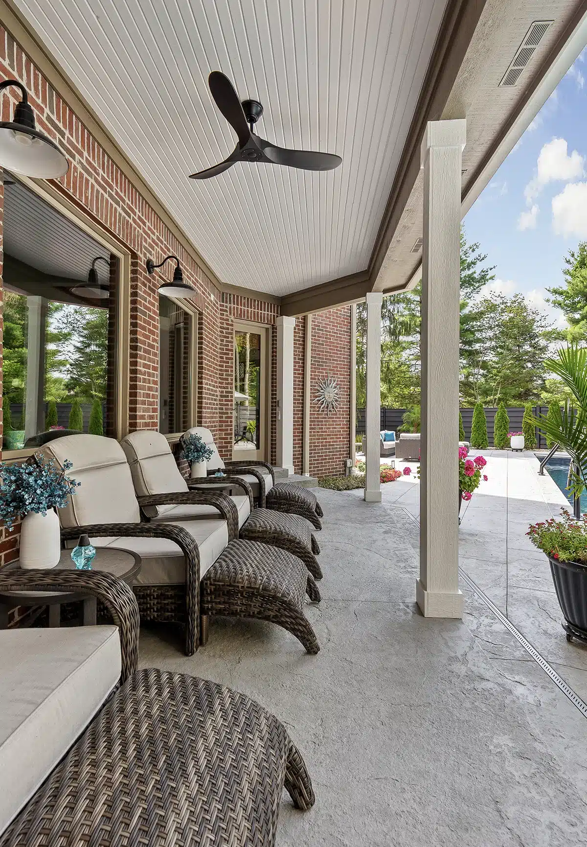Outdoor patio seating area Covered patio with cushioned lounge chairs overlooking the pool and landscaped backyard.